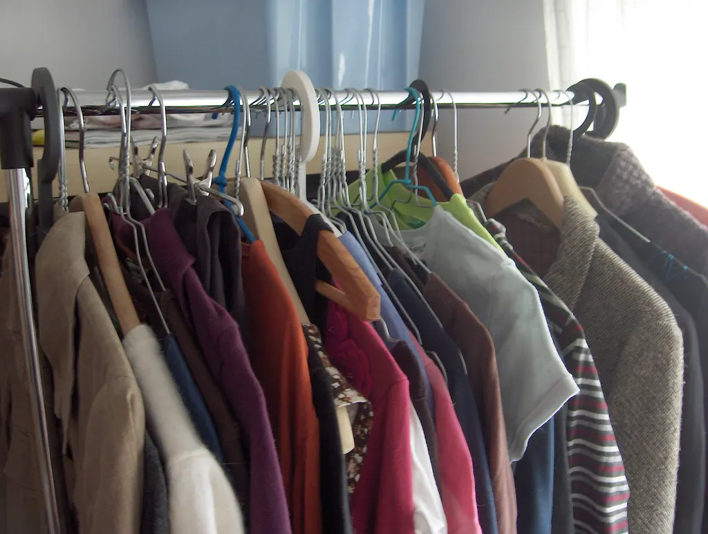 Arara com roupas coloridas penduradas, como numa loja que pode usar o anúncio de live no Instagram para mostrar a coleção nova