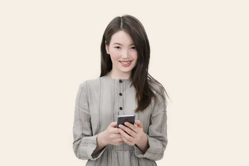 Mulher sorrindo com o celular na mão, cliente com perfil certo que responde ao anúncio