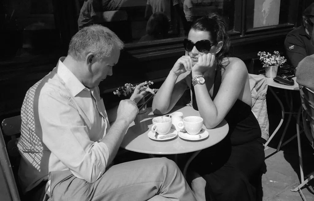 Homem olhando o celular numa mesa de café, como o seguidor que abre o canal do WhatsApp quando tem tempo