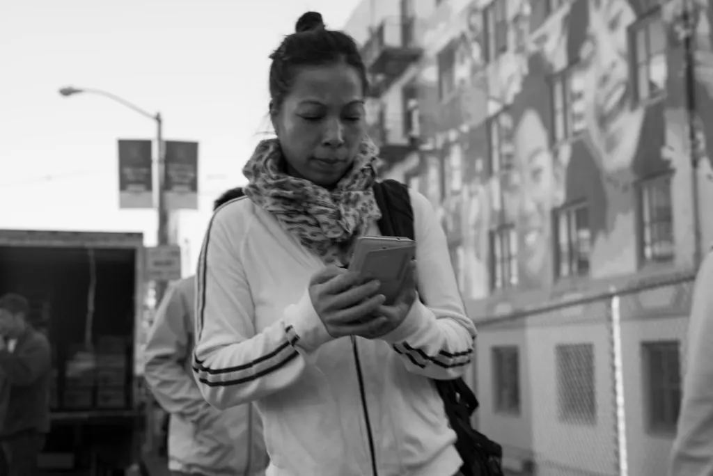 Mulher digitando no celular na rua, como o cliente que recebe a mensagem de follow-up