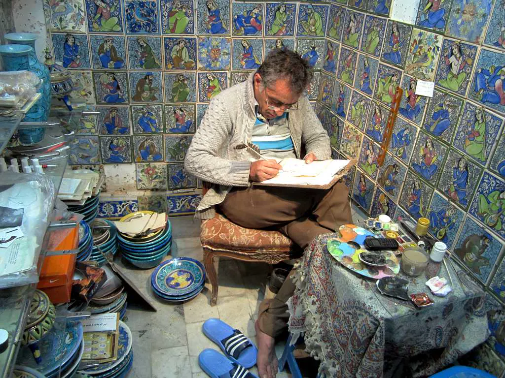 Artesão concentrado pintando uma peça em seu ateliê, um dos perfis que o Gemini para pequenas empresas quer atender