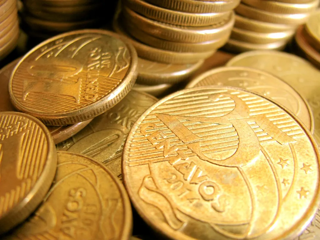 Moedas de real empilhadas, representando o cálculo do IBS e CBS no Simples Nacional