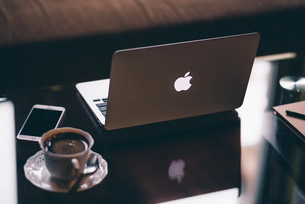 Notebook, celular e xícara de café sobre a mesa, como a rotina do dono que vai testar o Meta Muse para empresas