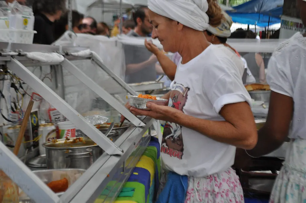 Feirante servindo comida em barraca de feira, um dos negócios que podem crescer com o novo limite do MEI