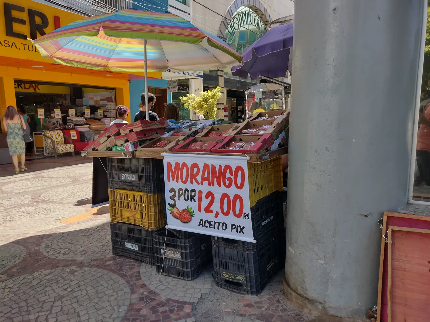 Barraca de morangos na calçada com faixa de preço e o aviso aceito Pix