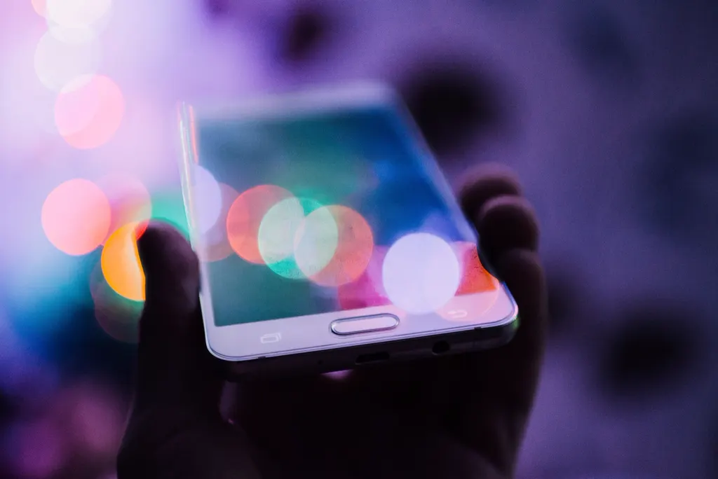 Celular iluminado com luzes coloridas desfocadas ao fundo, simbolizando quanto custa anunciar no Instagram