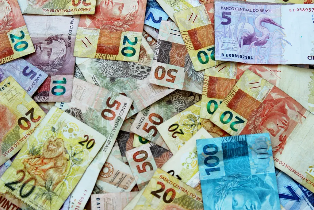 Cédulas de real espalhadas, representando quanto custa um funcionário CLT além do salário