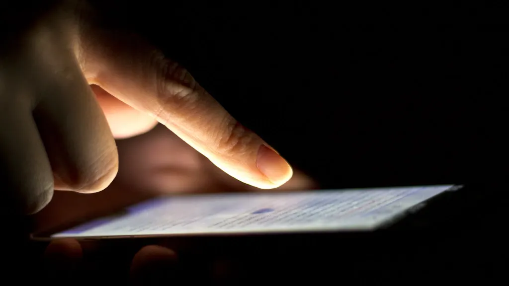 Dedo tocando a tela de um celular, como alguém que pesquisa no Google e clica num anúncio