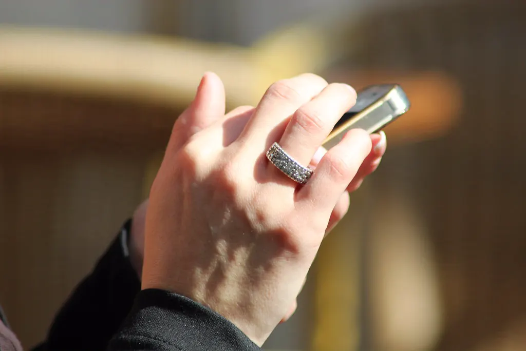 Mão segurando o celular para responder clientes com respostas rápidas do WhatsApp Business
