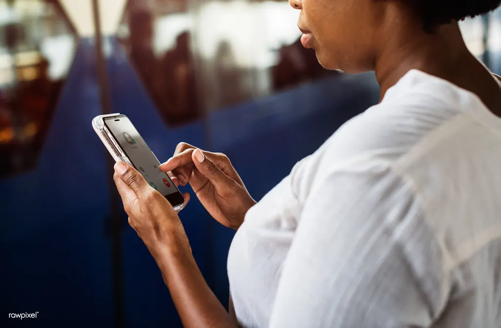 Mulher no celular aprendendo a responder avaliação negativa no Google pelo Perfil da Empresa