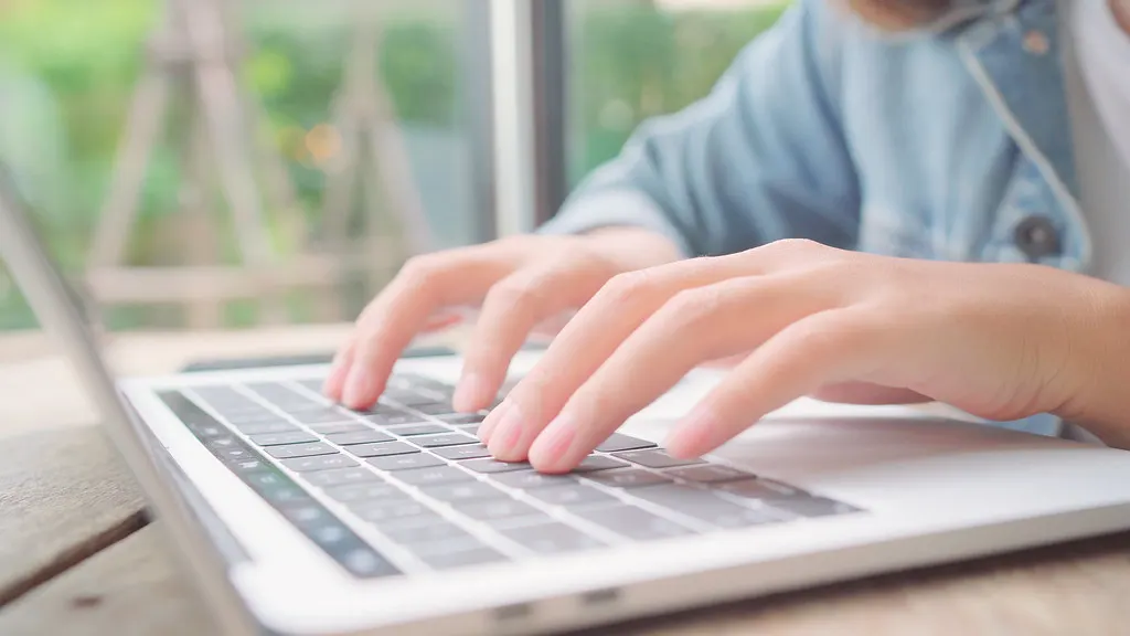 Mãos digitando no notebook, criando instruções salvas com as skills do Gemini
