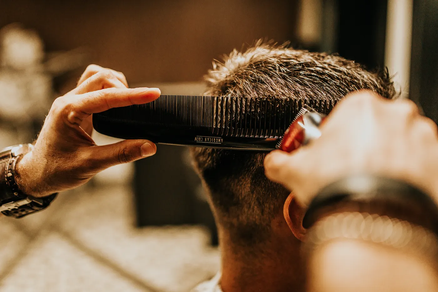 Barbeiro cortando cabelo com pente e máquina, um tipo de negócio em que o TikTok para empresa costuma funcionar bem