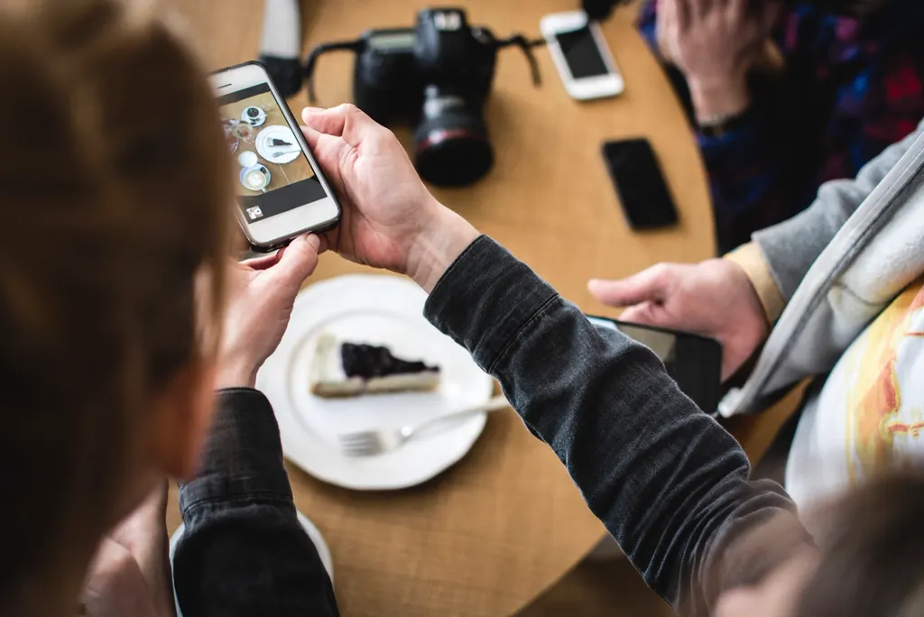 Pessoa filmando uma fatia de torta com o celular, como a empresa que se prepara para os vídeos longos no Instagram